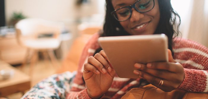 woman using a tablet on couch