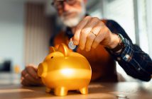 Person putting change in a piggy back.