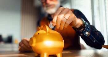 Person putting change in a piggy back.