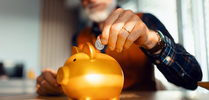 Person putting change in a piggy back.
